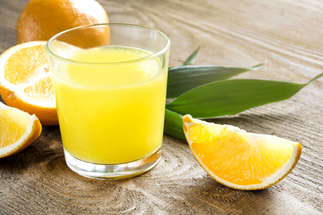 橙子木制背景上有橙汁和橙子的玻璃杯特写镜头柑橘水果食品柑橘