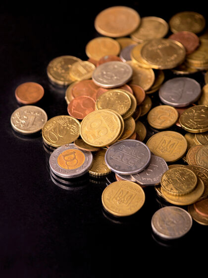 银在黑色背景上堆叠不同国家的硬币全球交换贸易