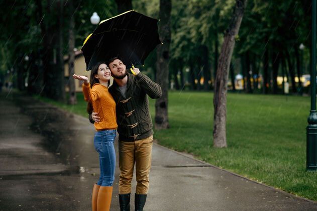 男人幸福的爱情夫妻享受夏日的雨天戴曼雨中的女人站在雨伞下 漫步小径上的浪漫约会 小巷里的潮湿天气森林自然女朋友
