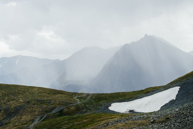 阴天美丽的阿尔卑斯山景观 在阳光透过云层的照射下 有着尖尖的山峰高山冒险巨大