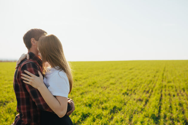关系一对年轻漂亮的情侣在一片绿地上拥抱着风景快乐男性