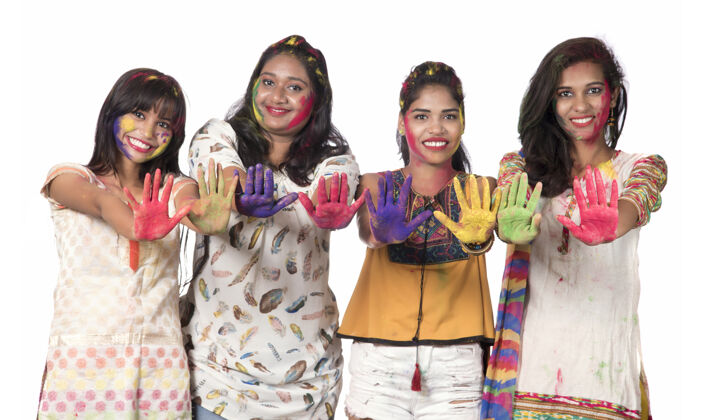 表情一群快乐的年轻女孩在胡里节上用五颜六色的粉玩得很开心庆祝多彩美丽