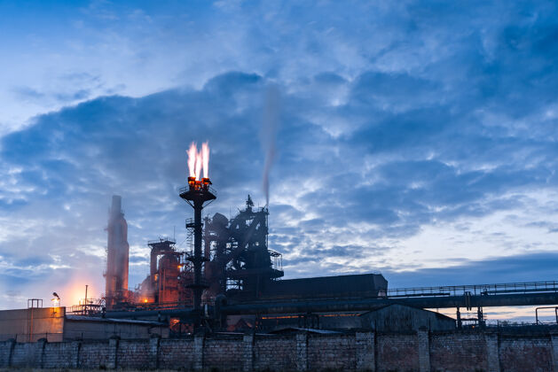 工厂暮色中的化工厂景观有管道和烟雾 有灯光和烟雾 长时间曝光建筑烟囱天空