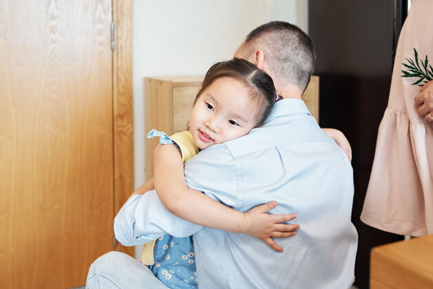 后代快乐可爱的越南小女孩拥抱着刚下班的父亲女人父母童年