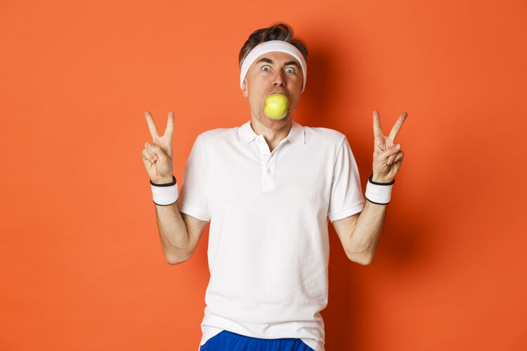 吃有趣的中年运动员的肖像 嘴里叼着苹果人成熟男人
