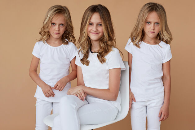 金发前面的特写肖像三姐妹金发卷发穿着白色衣服年轻小时尚
