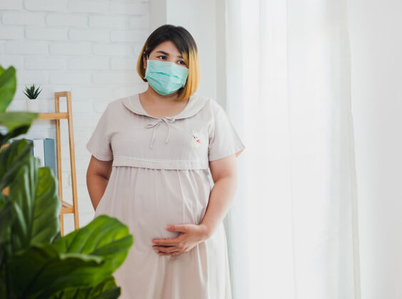 亚洲人亚洲孕妇戴上防护口罩以防细菌保护女人妈妈