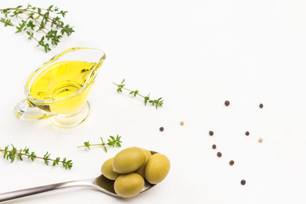 水果金属绿橄榄勺子橄榄玻璃中的油百里香小枝顶部查看油处女开胃菜
