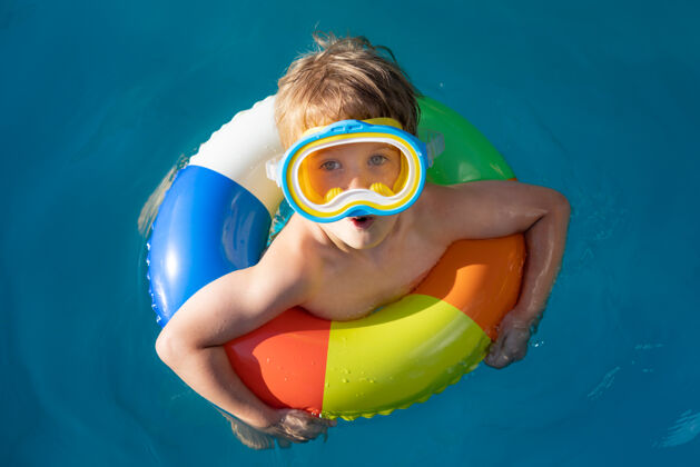 戒指快乐的孩子在游泳池里游泳放松充气游泳
