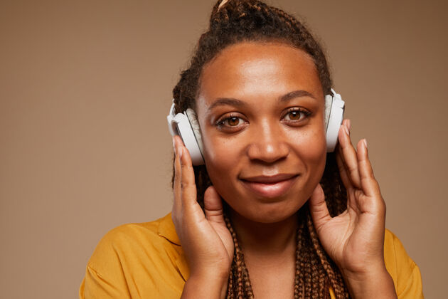 音乐非洲妇女戴着无线耳机听音乐的特写镜头电话非洲人后裔美女