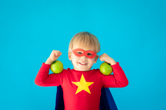 孩子超级英雄小孩拿着苹果超级英雄保护饮食
