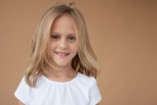 工作室特写正面肖像美丽的小女孩波浪金发 穿着白衬衫快乐金发小