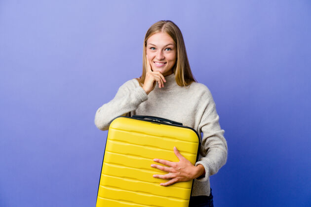 包年轻的俄罗斯女子抱着手提箱旅行 微笑着快乐而自信 用手抚摸着下巴优雅护照可爱