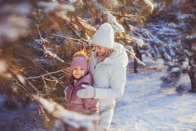 户外妈妈和女儿在冬季公园玩得很开心公园快乐幼儿