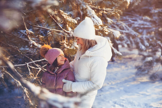 散步妈妈和女儿在冬季公园玩得很开心寒冷妈妈父母