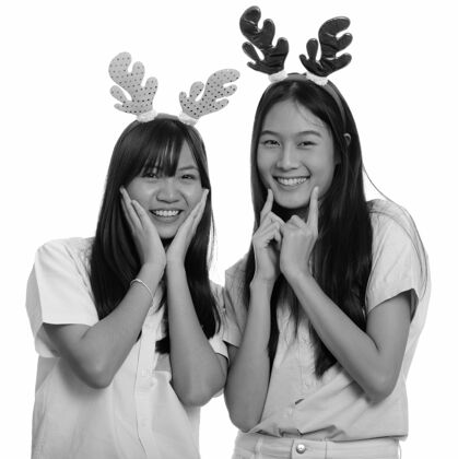 漂亮两个年轻漂亮的亚洲少女一起被隔离在黑白相间的白墙上季节微笑青少年