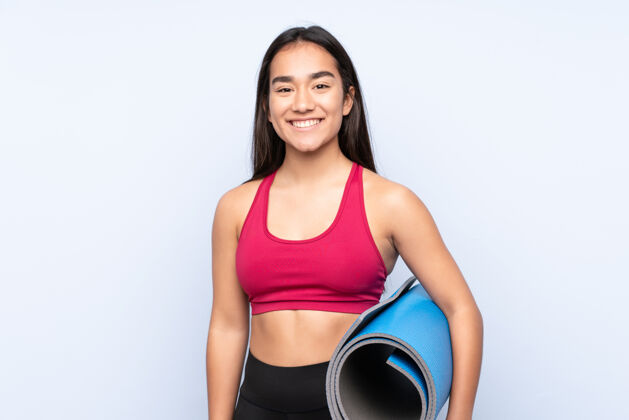 女人一个年轻的印度女运动员 穿着蓝色的垫子 面带微笑运动员年轻人健身房