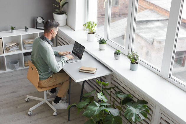 软件在宽敞的办公室里 电脑程序员坐在办公地点用笔记本电脑打字现代坐着长相