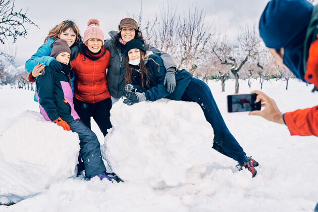 女孩一个男孩用家里的手机拍了一张照片 雪地里有五个快乐微笑的白人女孩欢乐户外季节