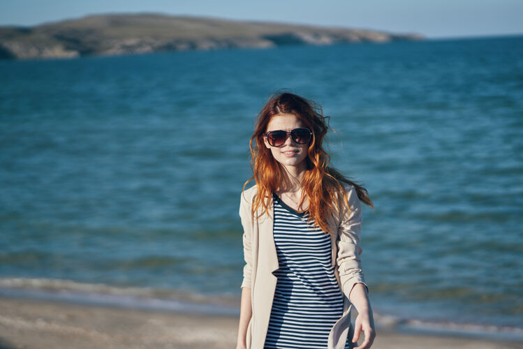 海岸穿着T恤和夹克的旅行者在海边的海滩上微笑欢乐优雅