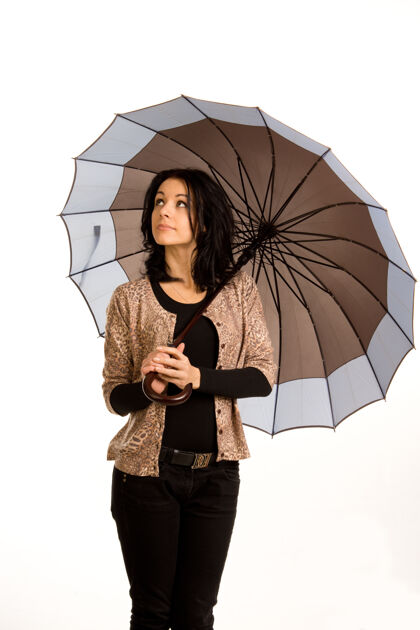 漂亮美丽时尚的年轻女子撑着雨伞仰望天空看天气姿势肖像女士
