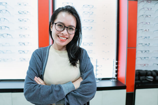 销售一个美丽的微笑的女人在一个眼镜展示窗口背景眼科诊所视觉购买镜头