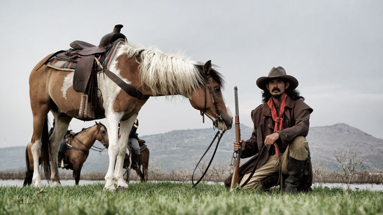 自然牛仔骑在马背上迎着美丽的日落骑士头盔剪影