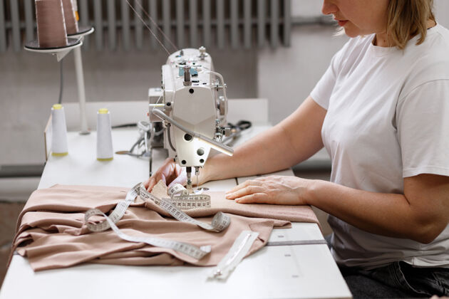 设备工厂里缝纫机后面的女裁缝室内针纺织品