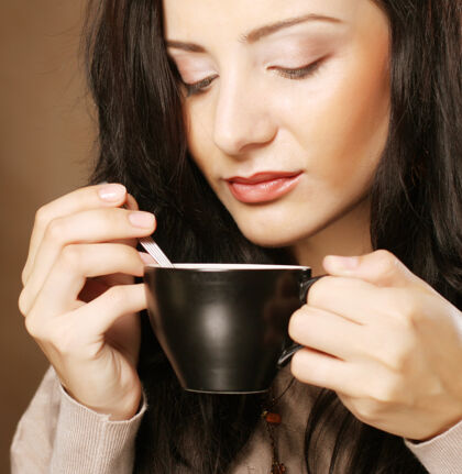 茶年轻漂亮的黑发女人在喝咖啡咖啡单身放松