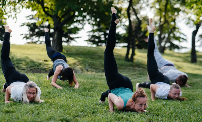 冥想一群人在日落时分在公园里做瑜伽健康的生活方式 冥想和健康锻炼女人垫子