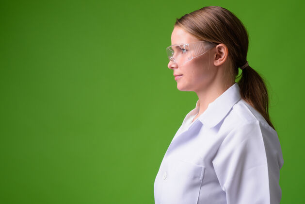 视图年轻漂亮的金发女医生戴着绿色防护眼镜的画像长款面部人物