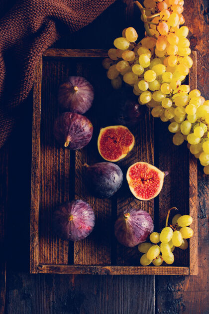 配料新鲜的葡萄和无花果在一个古老的木制表面复古风格切割百里香俯视图
