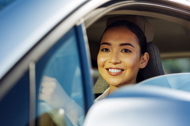 车辆积极的心情愉快的好女人微笑着开车城市领导白天