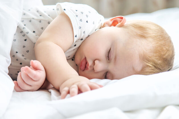 肖像宝宝睡在白色的床上谎言童年放松