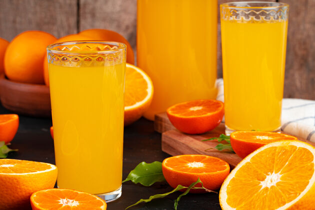 果汁一杯橙汁和切好的橙子放在桌上食物多汁切割
