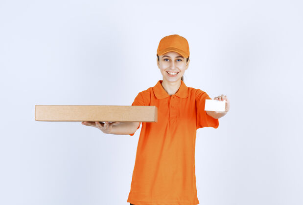 模特身着橙色制服的女快递员手持外卖披萨盒 出示名片年轻智能运输