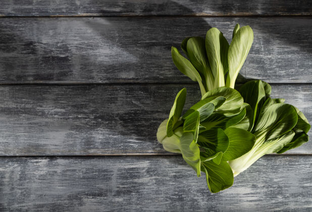 新鲜新鲜的绿色大白菜放在灰色的木头表面上饮食莴苣卷心菜