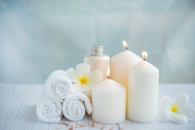 按摩轻木表面的Spa椰子产品由毛巾 鲜花和盐 蜡烛组成 放在Spa沙龙的按摩台上东方水疗蜡烛