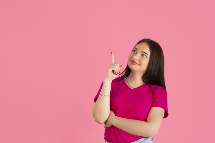 商业年轻的白人黑发女人站在粉红色的墙上事业模特女性