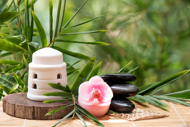 竹子竹叶绿叶 温泉概念与禅宗和黑石水疗蜡烛产品