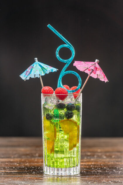 伏特加绿色鸡尾酒在一个高杯装饰着橙色 覆盆子和蓝莓水果特写健康