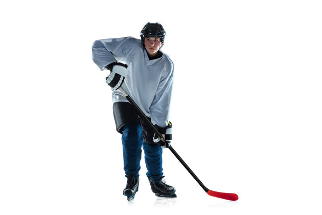 专业跑步冰球场上有棍子和白色背景的年轻男子冰球运动员运动员穿着装备和头盔练习运动概念 健康的生活方式 运动 运动 动作运动员团队合作比赛