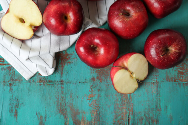 美味成熟的红苹果放在彩色木桌上乡村木材切割