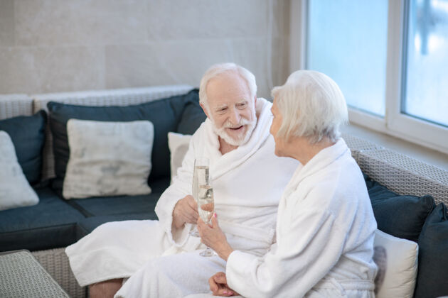 成熟对话成熟一对穿着白色长袍的夫妇坐在沙发上讨论着什么美好生活美容中心水疗中心