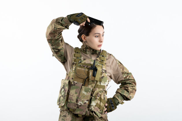 私人前视图：白墙上带枪的伪装女兵坦克军装衣服