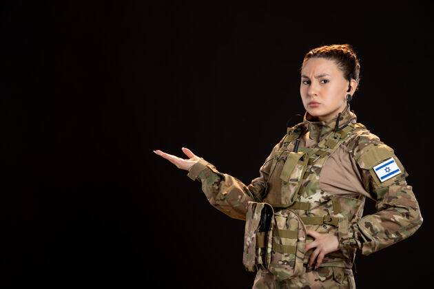 伪装黑墙上穿迷彩服的女兵制服人肖像