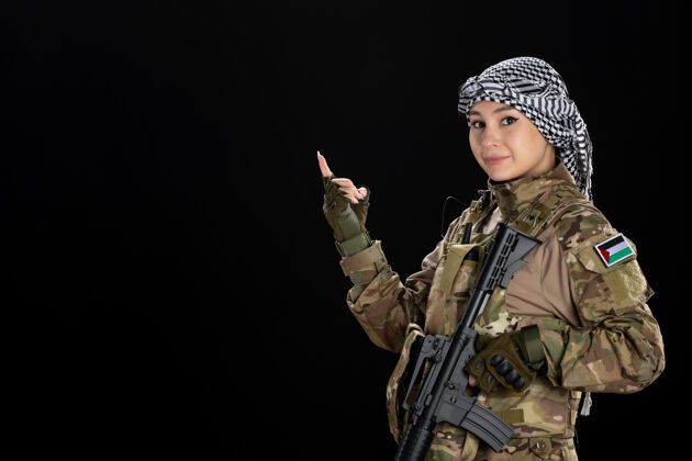 军人穿军装的女兵在黑墙上拿着步枪黑色女人步枪