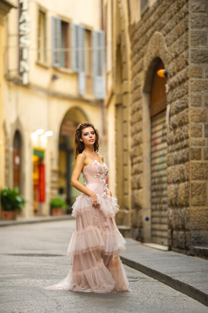 微笑一个穿着粉色婚纱的新娘走在意大利佛罗伦萨时尚时尚新娘蜜月