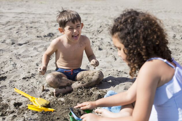 假期在沙滩上玩的中枪小孩家庭夏天乐趣
