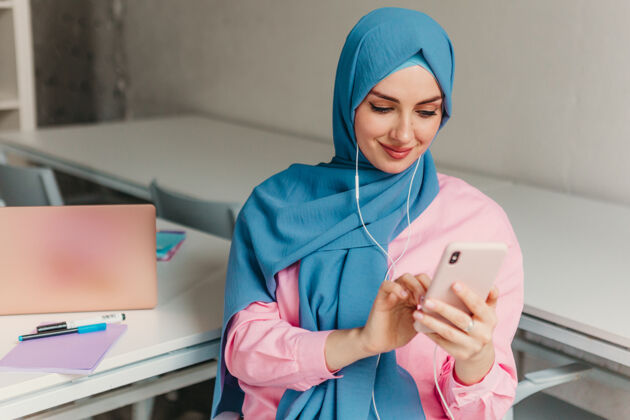 工作场所年轻漂亮的现代穆斯林妇女戴着头巾在办公室的笔记本电脑上工作 教育在线电话头巾女性
